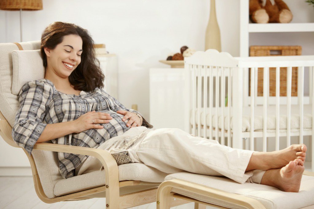 Беременная женщина сидит в кресле