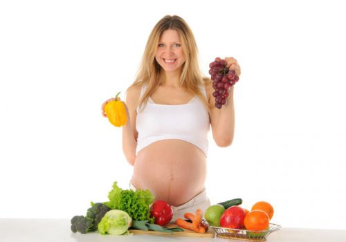 Беременная выбирает фрукты и овощи
