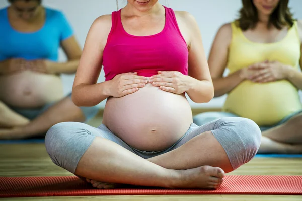 Беременные женщины, делающие упражнение на расслабление — стоковое фото