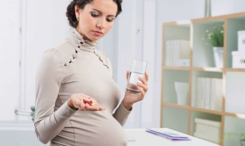Беременная принимает таблетки