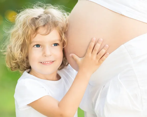 Ребенка слушать живот беременной женщины — стоковое фото