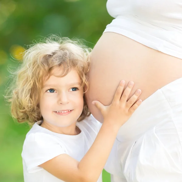 Ребенок Холдинг живот беременной матери — стоковое фото