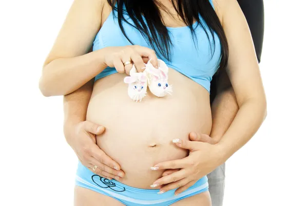 Беременный живот девушки с пинетки — стоковое фото