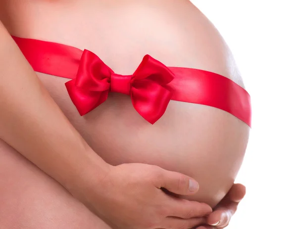 Беременный живот с подарок лук. Беременность — стоковое фото