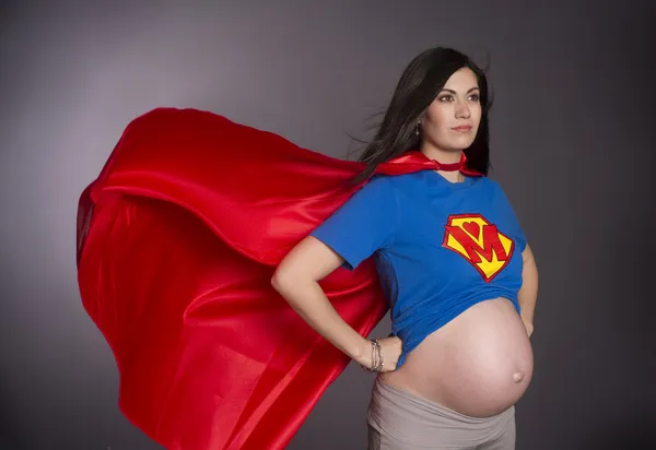 Беременная женщина мать характер супер герой красный мыса груди Crest — стоковое фото