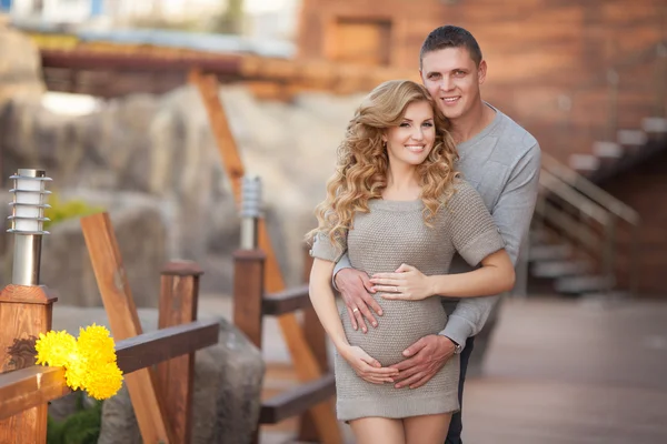 Молодая беременная женщина с мужем ходить открытый и объятия животик — стоковое фото
