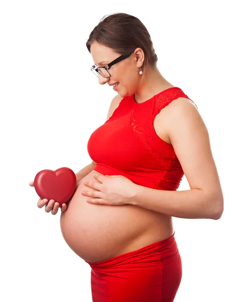 Счастливым беременная женщина держит сердце рядом с ее большой живот — стоковое фото