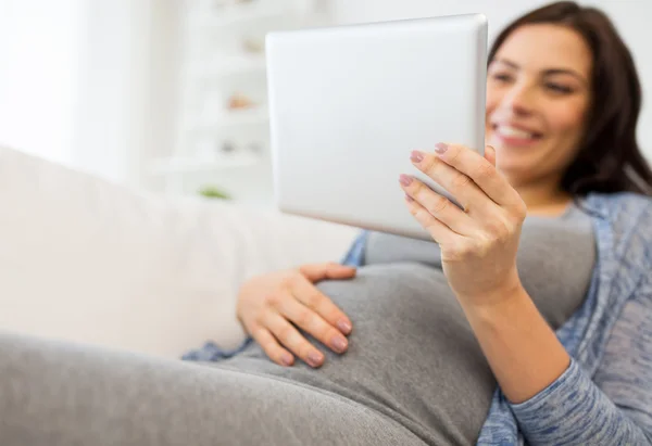 Заделывают беременной женщины с планшетного ПК на дому — стоковое фото