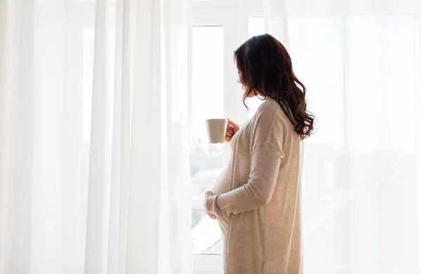 Заделывают беременной женщины с чаем в окно — стоковое фото