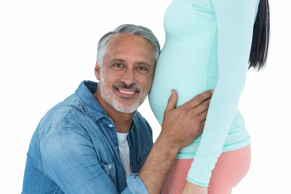 Человек, слушая живот беременной женщины — стоковое фото