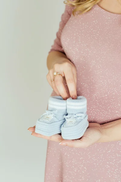 Беременная мать, холдинг маленькая Детская обувь — стоковое фото
