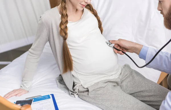 Врач, изучающий беременную женщину — стоковое фото