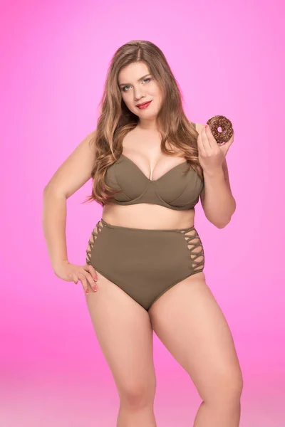 Женщина, держащая пончик с избыточным весом — стоковое фото