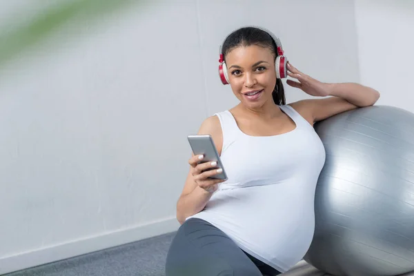 Афро Американских Беременная Женщина Прослушивания Музыки Наушниками Смартфон Сидя Нужным — стоковое фото