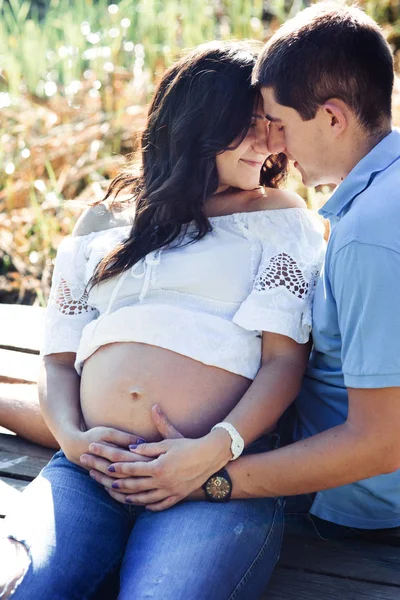 Мужчина и беременная женщина у озера — стоковое фото