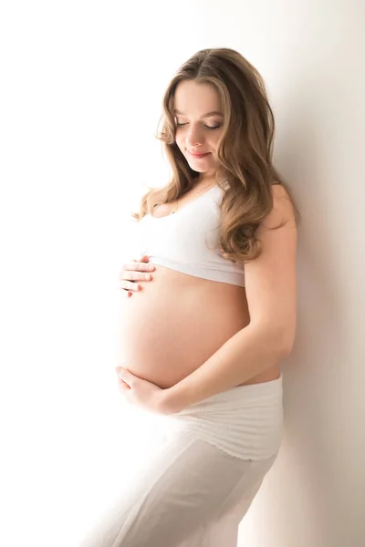 Беременная женщина с большой живот на белом фоне — стоковое фото