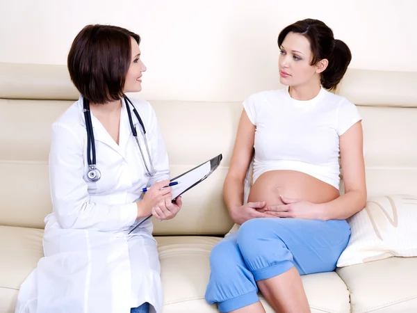 Доктор переговоры с беременной женщины — стоковое фото