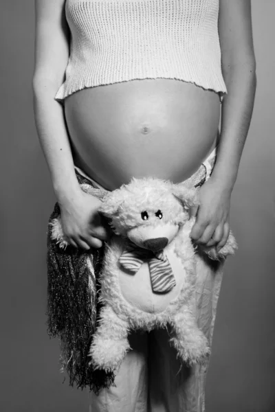 Беременный живот и сладкий Мишка — стоковое фото