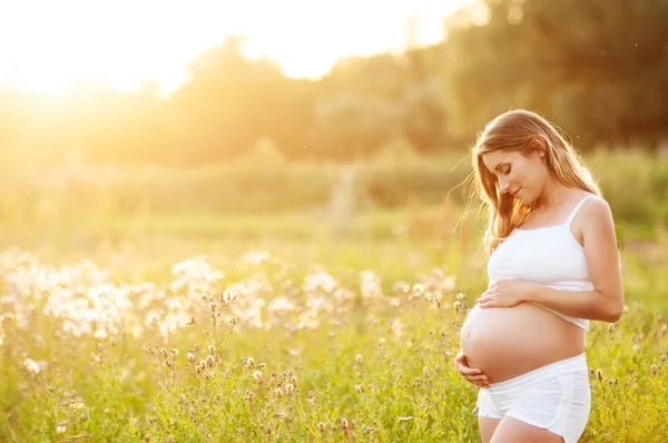 Красивая беременная женщина расслабляющий в парке — стоковое фото